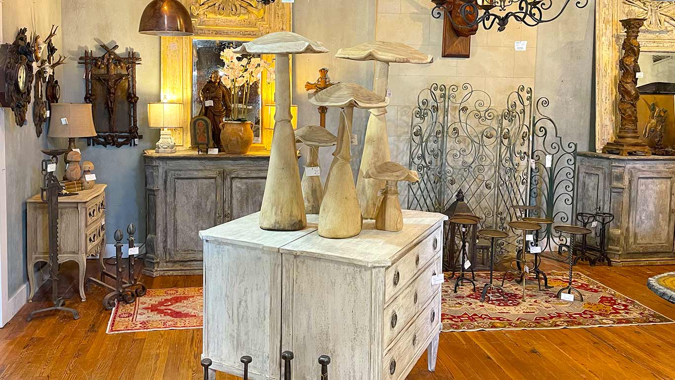 pair of bleached chests with wooden carved mushrooms on top and antiques in background